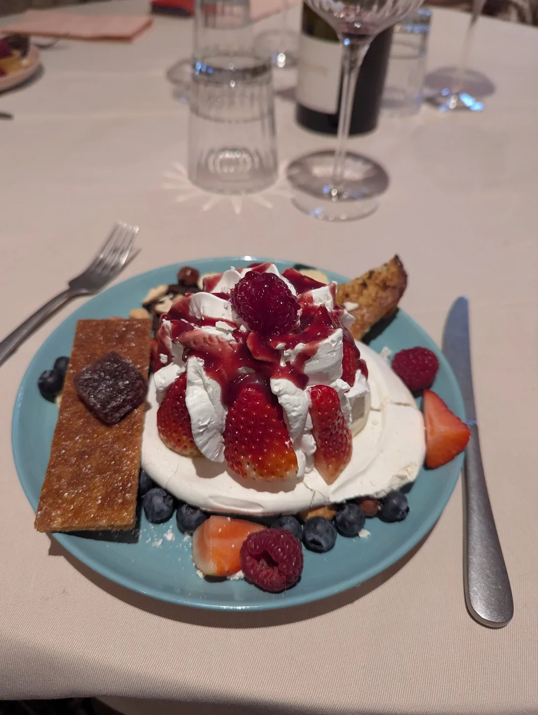 Meringue, fraises et fruits rouges sur une assiette bleue