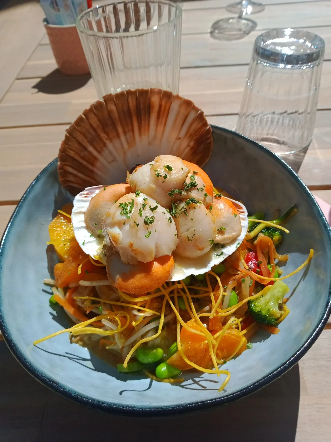 Noix de Saint-Jacques dans leur coquille, sur une julienne de légumes
